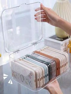 a person holding a clear plastic case on top of a table