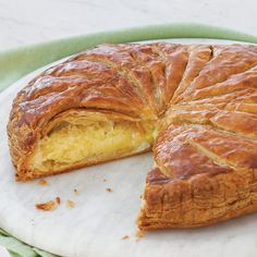 a large piece of pie on a white plate with a green towel next to it