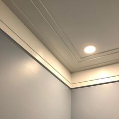 an empty room with white walls and recessed lighting on the ceiling, is pictured in this image