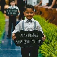 a young boy holding a sign that says calma mennas and estoto solterio