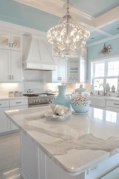 a white kitchen with marble counter tops and an island