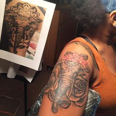 an elephant tattoo on the arm of a woman's right arm, with roses around it