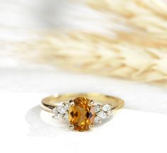 an orange and white diamond ring sitting on top of a table