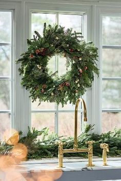 a christmas wreath is hanging on the window sill in front of a kitchen sink