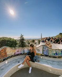 a woman sitting on top of a skateboard ramp