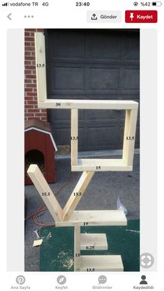 a wooden table with measurements for the top and bottom pieces on it, in front of a garage door