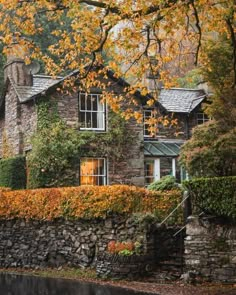 an old stone house surrounded by autumn foliage