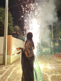 a woman standing in front of a firework display