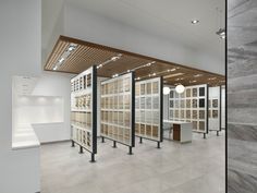 an empty room with several glass cases in the center and two rows of shelves on each side