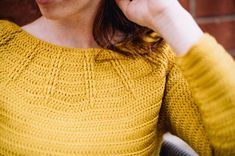 a woman in a yellow sweater is talking on her cell phone