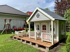 a small wooden house sitting on top of a lush green field