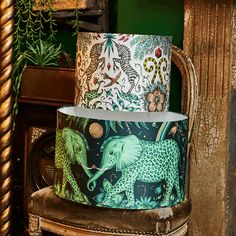 two lampshades decorated with elephants and plants