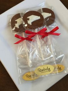 chocolate covered pretzels wrapped in cellophane and tied with red ribbon on a white plate