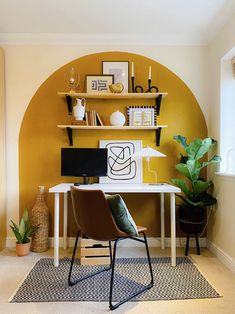 a home office with yellow walls and black chairs in front of a white computer desk