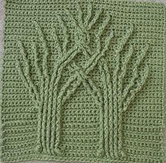 a crocheted square with trees on it