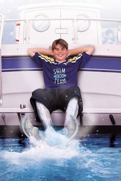 there is a man sitting on the back of a boat with his feet in the water