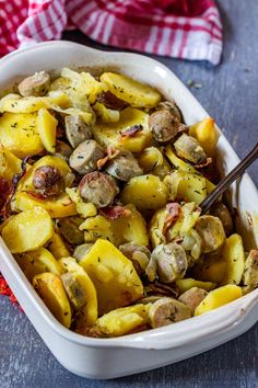 a casserole dish filled with potatoes, mushrooms and bacon on a blue surface