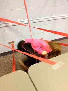 a woman in pink jacket sitting on chair next to red tape