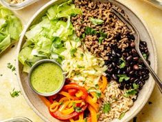 a salad with black beans, lettuce and tomatoes in a bowl on a table