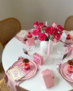 a white table topped with pink plates and flowers