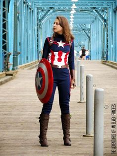 a woman dressed as captain america standing on a bridge