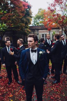 a group of men in tuxedos standing around