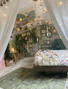 a bed with white curtains and lights hanging from it's sides in a bedroom