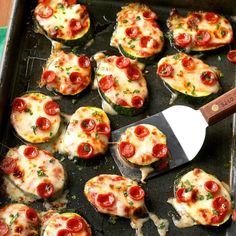 a pan filled with mini pizzas on top of a table