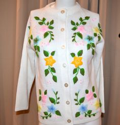 a white cardigan with colorful flowers on it