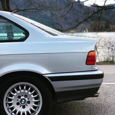 a silver car parked in a parking lot next to a lake