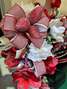 a red and white christmas wreath on top of a table