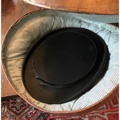 two black plates sitting on top of a wooden table next to a red and white rug