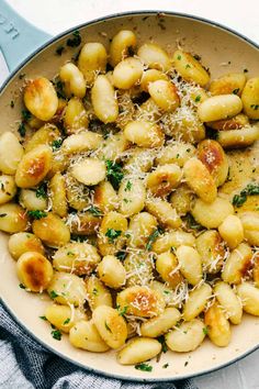 a skillet filled with gnocchini and parmesan sprinkled cheese