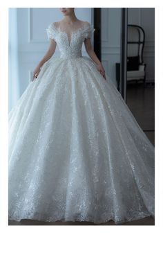 a woman in a white wedding dress standing next to a mirror