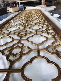 an intricately designed metal screen is shown in the process of being painted and polished