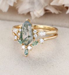 a close up of a ring on a white surface with flowers in the background,