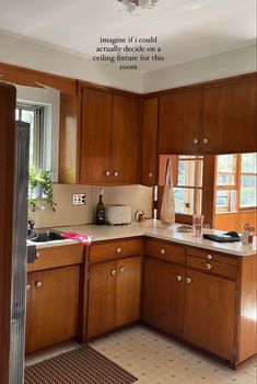 a kitchen with wooden cabinets and tile flooring is shown in this image, there is an open window above the sink