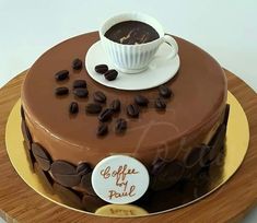 a chocolate cake with coffee beans on top and a cup of coffee in the middle