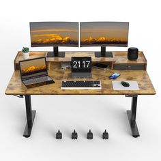 two computer monitors sitting on top of a wooden desk next to a laptop and mouse