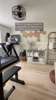 a girl is running on a treadmill in the living room with a sign above her