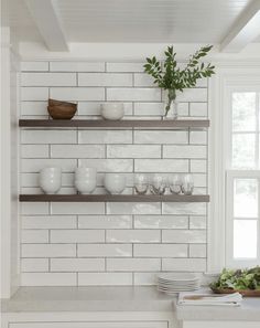 the shelves in this kitchen are filled with dishes