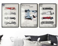 three vintage cars are hanging on the wall above a couch in a room with pillows