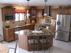 a kitchen with stainless steel appliances and granite counter tops, along with wooden cabinetry