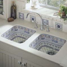 two blue and white kitchen sinks sitting next to each other in front of a window