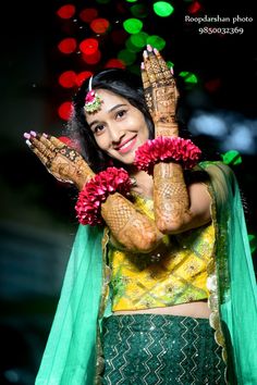 a woman with henna and flowers on her hands