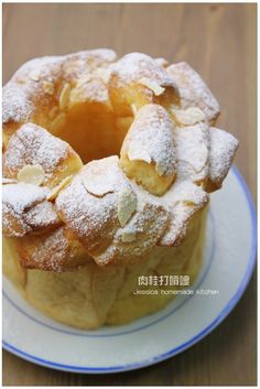 a bundt cake with powdered sugar on top sits on a blue and white plate