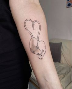 a woman's arm with a small rat tattoo on it