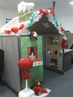 an office cubicle decorated for christmas with presents on the roof and decorations around it