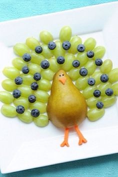 a plate with grapes on it and a turkey made out of grapes in the middle