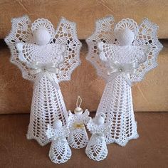 two white crocheted angel figurines sitting next to each other